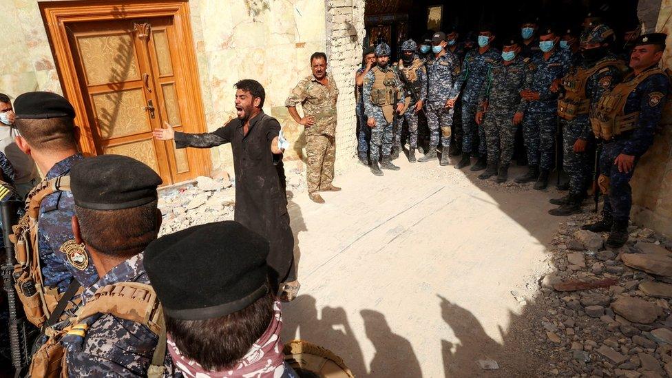 A man reacts as rescue workers search for survivors in the rubble of the collapsed Qattarat al-Imam Ali shrine in Iraq's Karbala region (21 August 2022)