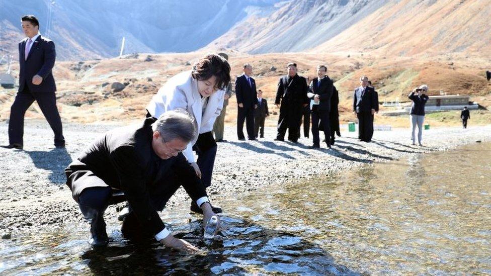 South Korean President Moon Jae-in with his wife Kim Jung-sook standing next to him, fills a plastic bottle with water from the Heaven Lake of Mt Paektu, North Korea, September 20, 2018.