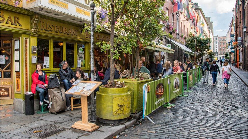 People sit outside pub in Dublin