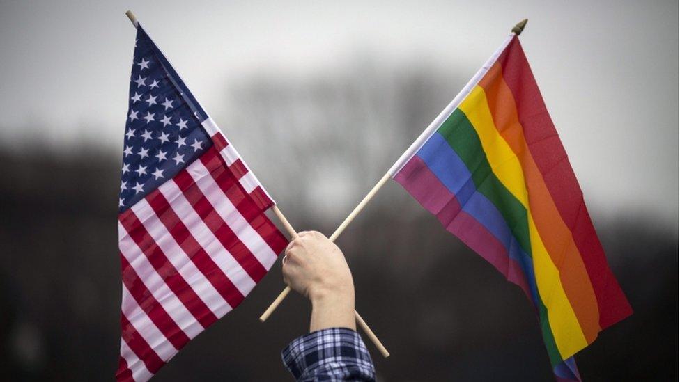 American and Pride flags held up