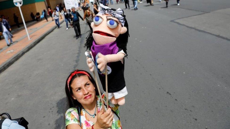 A woman holds a puppet during a protest as a national strike continues in Bogota, Colombia, November 27, 2019