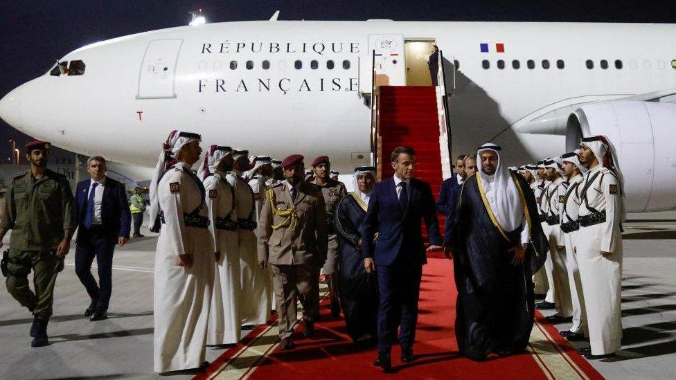 French President Emmanuel Macron is welcomed by officials of the Ministry of Foreign Affairs upon his arrival at Doha's airport, for a one-day visit to discuss with the Emir of Qatar