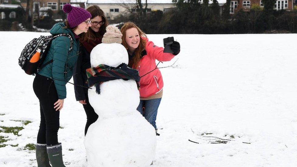 Woman take a selfie with a snowman in High Wycombe, Buckinghamshire.