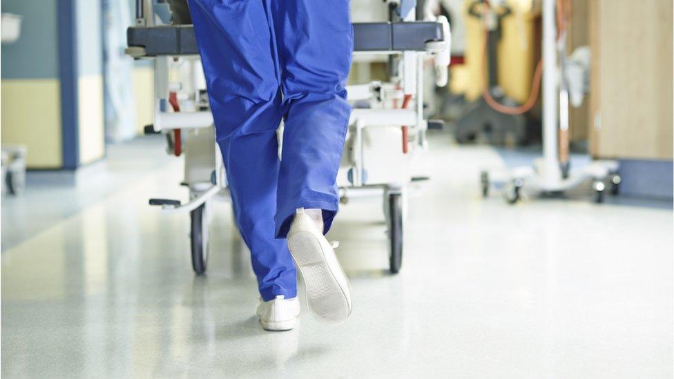 Anonymous hospital worker pushing a trolley