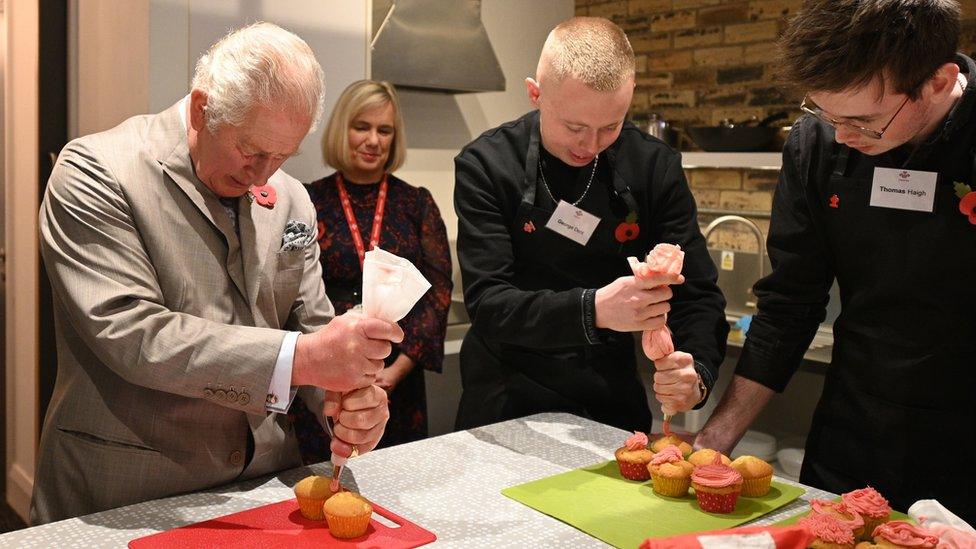 Prince Charles ices cupcakes made by young people on one of the courses.