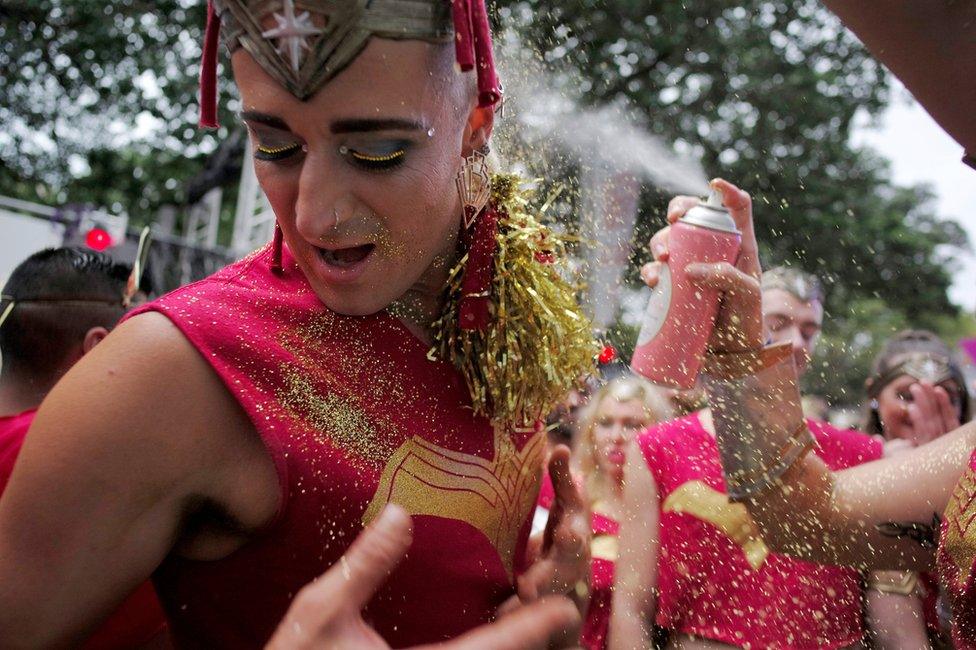 Glitter is sprinkled on a male participant in make-up, who turns his face from an accompanying adhesive spray, during the annual Sydney Gay and Lesbian Mardi Gras festival in Sydney, Australia March 4, 2017.