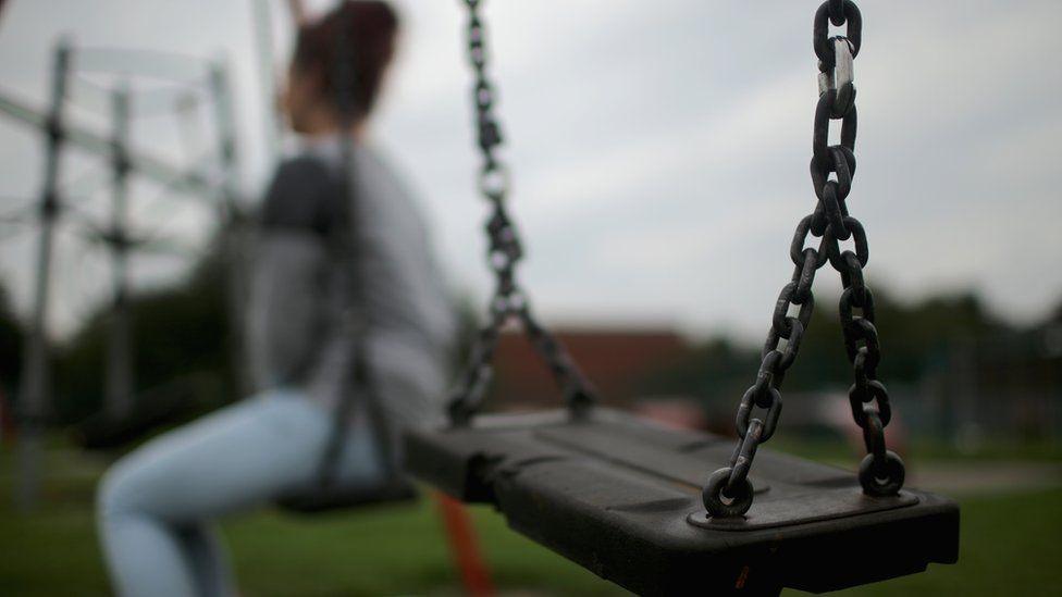 girl sitting on swings