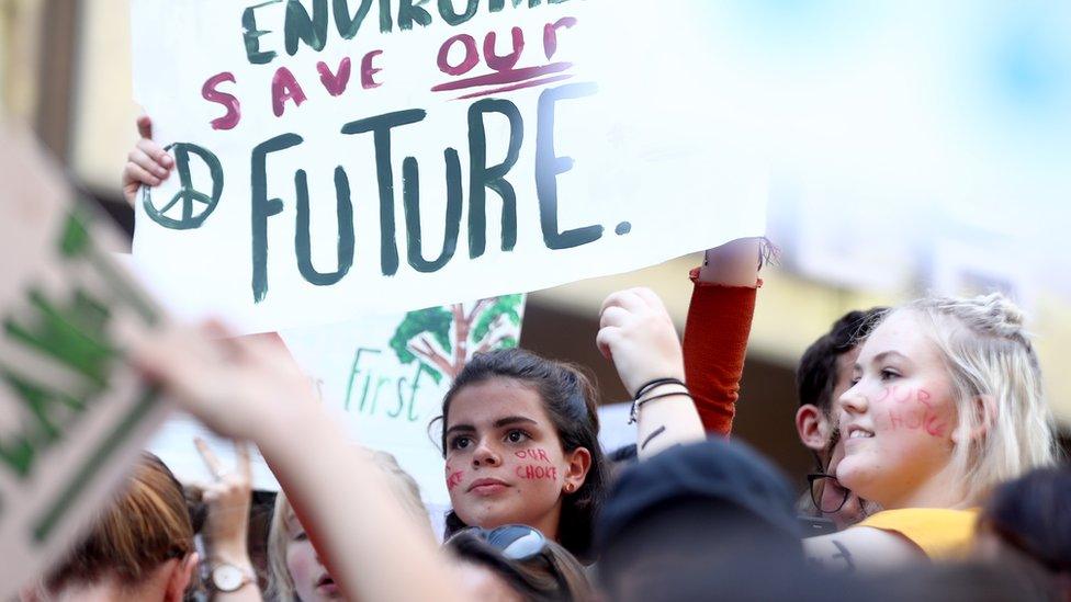 A girl protests in a crowd in Sydney for climate change action