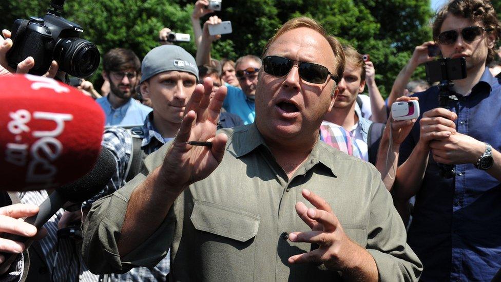 Man standing amidst reporters and cameras