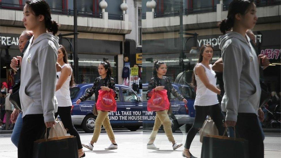 Oxford Street shoppers reflected in window