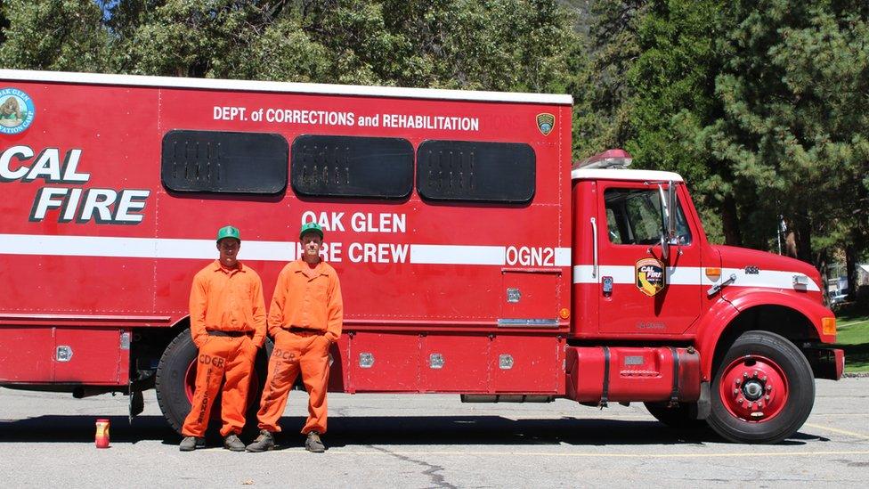 Inmates stand in front of fire engine