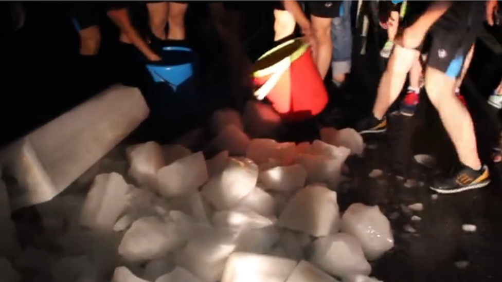 Students collecting ice into buckets at Lushan College in the Chinese city of Liuzhou.