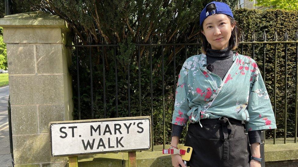 Lady stood in front of old street sign