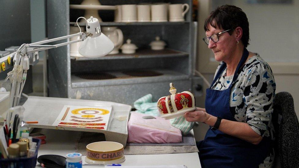 A pottery decorator adds details to a crown, during the production of hand-decorated pieces from the forthcoming King Charles III Coronation collection, at the Emma Bridgewater Pottery Factory in Stoke on Trent.