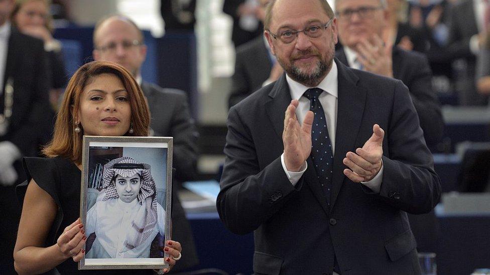 Ensaf Haider holds up a picture of Raif Baddawi as she collects the Sakharov Prize for Freedom of Thought from European Parliament President Martin Schulz in Strasbourg on 16 December 2015