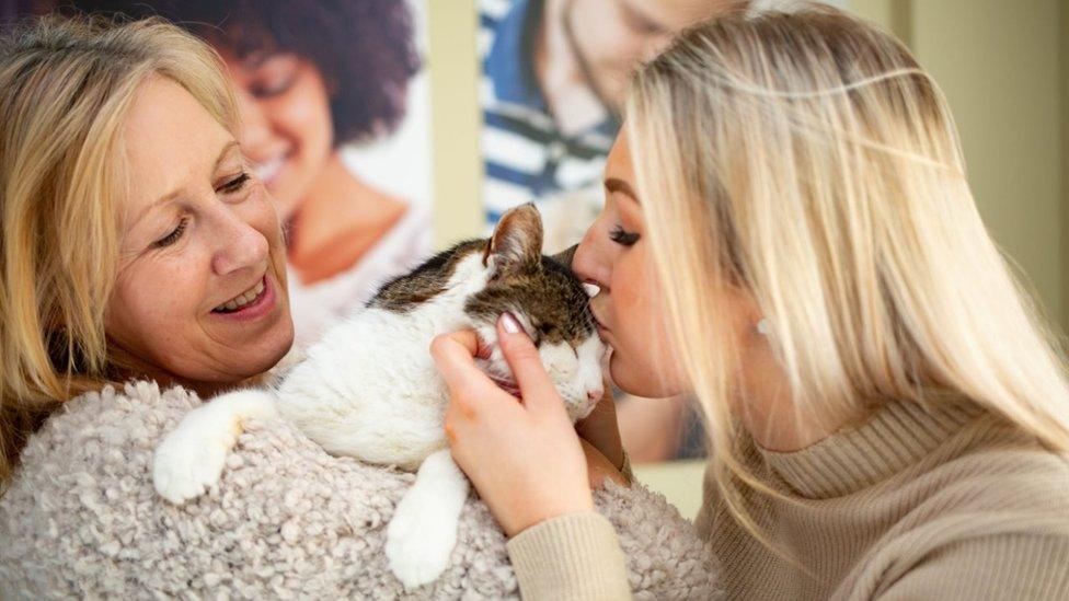 Peanut the cat with owners