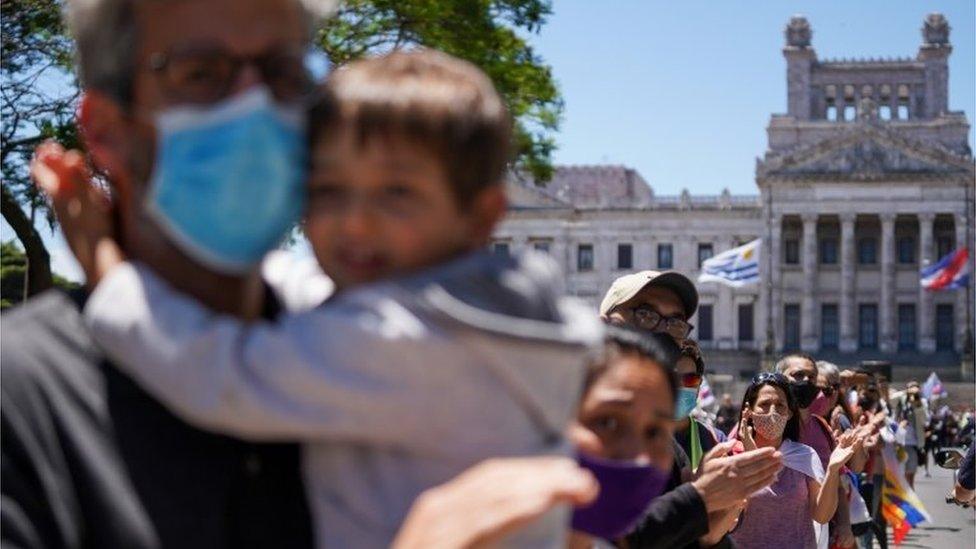 People stand near the Legislative Palace as they attend a funeral procession for Uruguayan former President Tabare Vazquez in Montevideo, Uruguay December 6, 2020