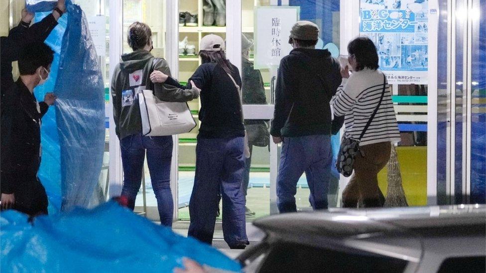 Relatives enter the facility where the bodies of the victims of the missing tour boat "Kazu 1" were laid, in Shari, Hokkaido Prefecture, Japan in this photo taken by Kyodo on April 24, 2022.