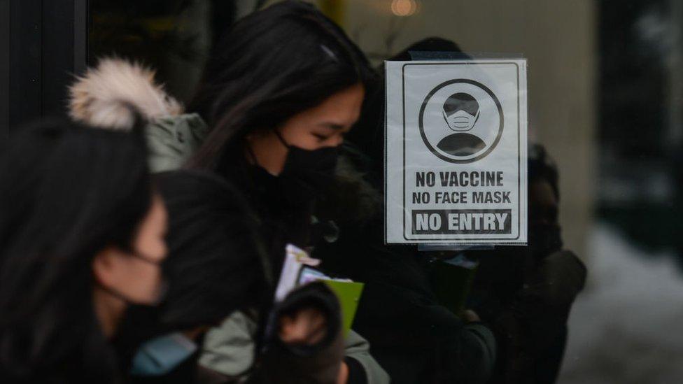 Sign 'No Vaccine, No Mask, No Entry' seen on the door of a store on Whyte Avenue in Edmonton. Monday, December 13, 2021, in Edmonton, Alberta, Canada