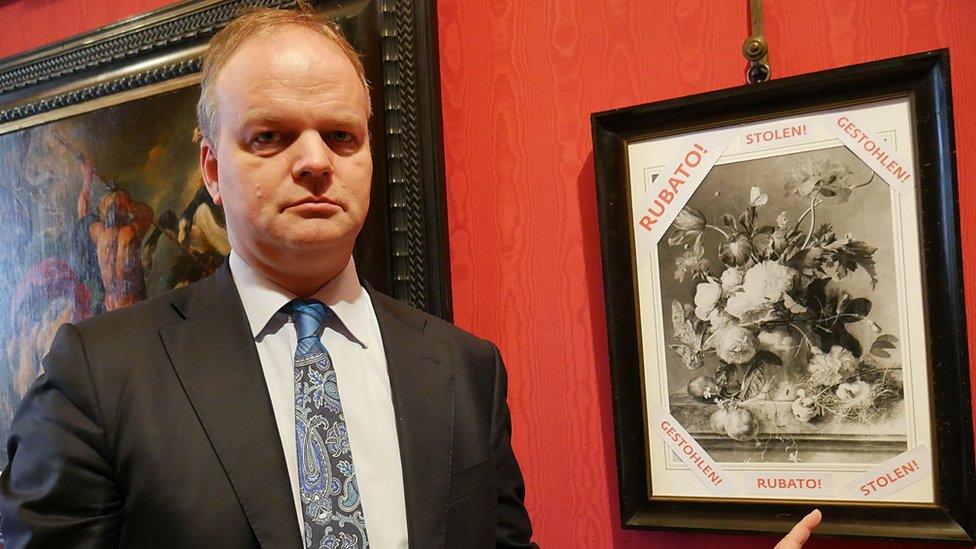 Uffizi gallery head Eike Schmidt with a photo of the stolen painting, Vase of Flowers