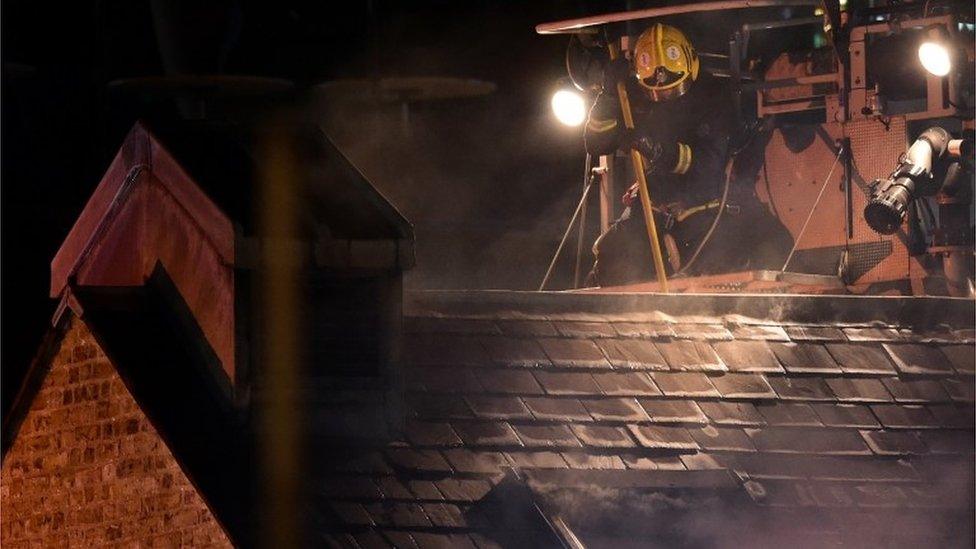 Firefighter on roof of burning Camden Lock building