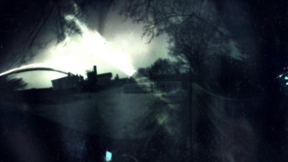 Solargraph featuring a building and trees. It is a black and white image