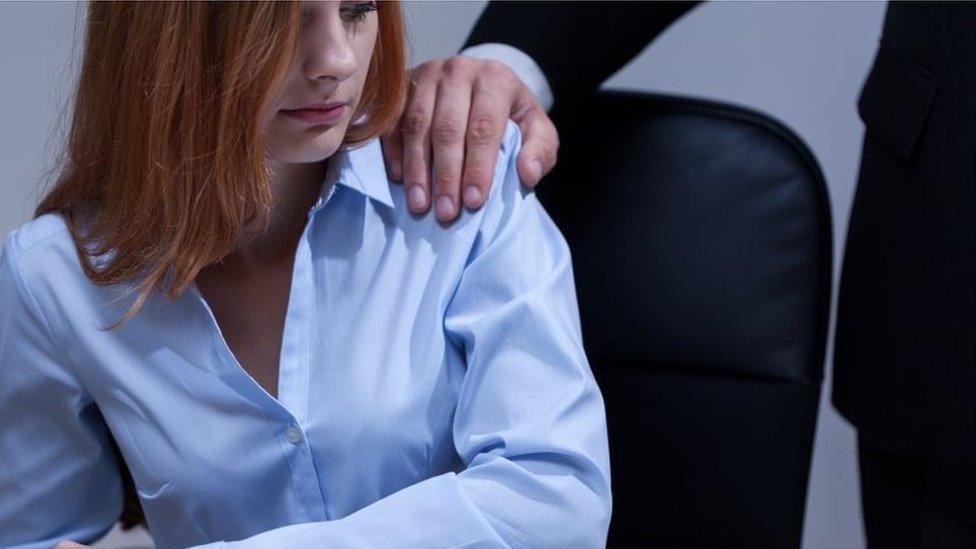 Man touches woman's shoulder