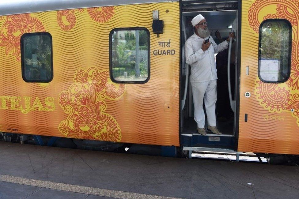 In this photograph taken on May 21, 2017, an Indian guard communicates with the driver during a trial of the Tejas Express luxury train the Tejas Express luxury train before its first journey between Mumbai and Goa at the Chattrapati Shivaji Terminus terminus station in Mumbai.