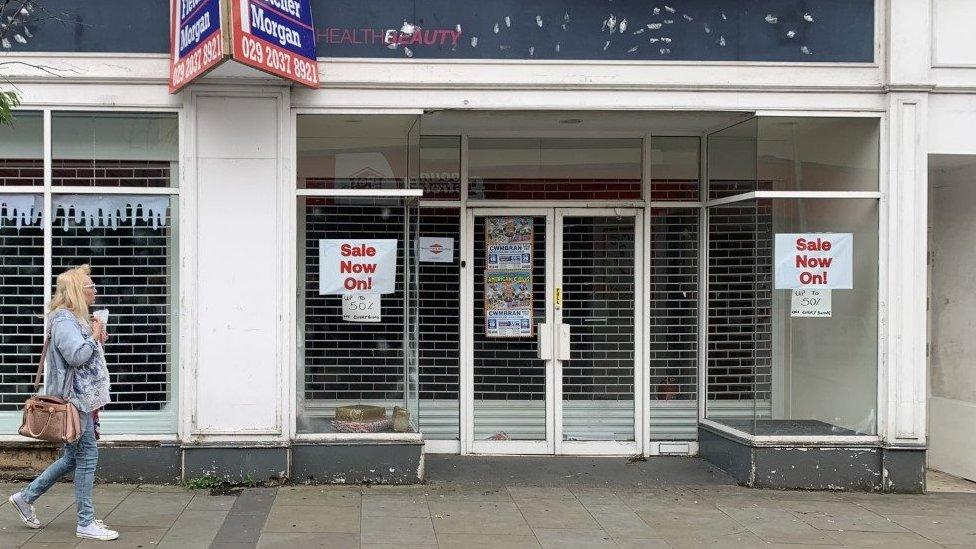 A woman walks past a dilapidated shop in Pontypool town centre