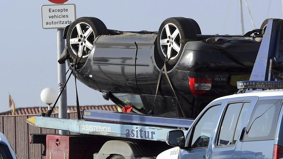 An upside-down car being driven on a transporter