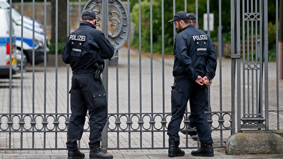 Police officers stand guard outside the district court building in Landau