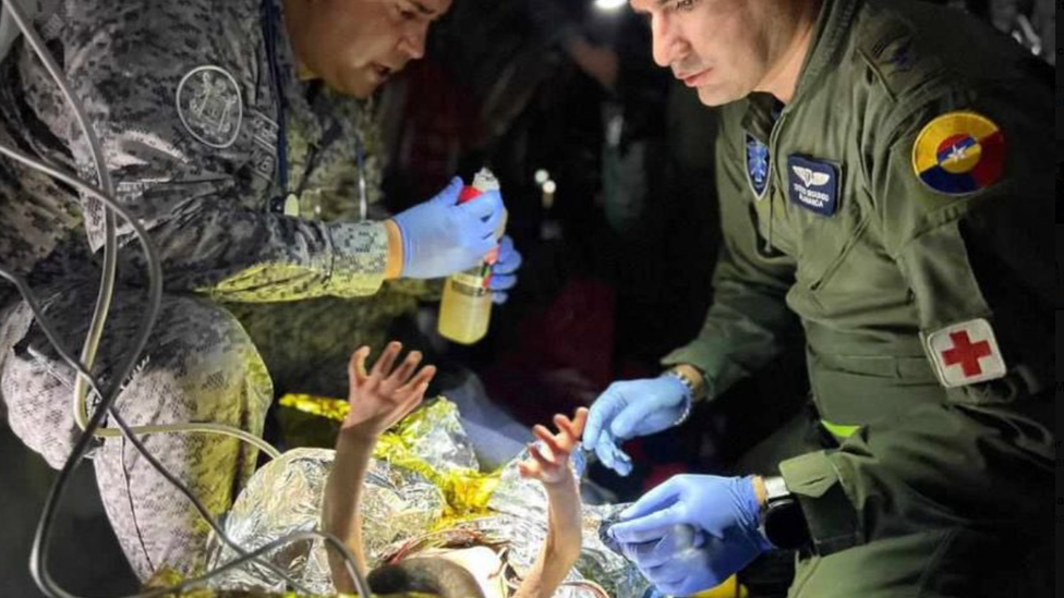 Rescue workers prepare bottle for baby