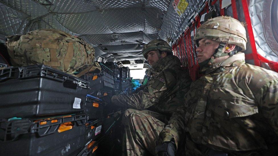 Soldiers inside a chinook taking supplies to Cumbria