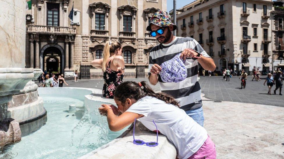 girl drinking from fountain