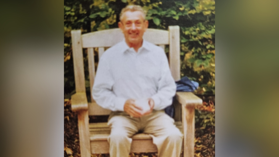 Old picture of Michael Lupton sat outside on a wooden chair