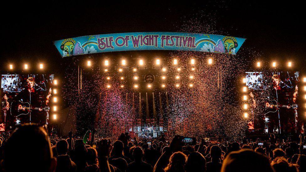 The festival's main stage at night with stage lights on and glitter falling