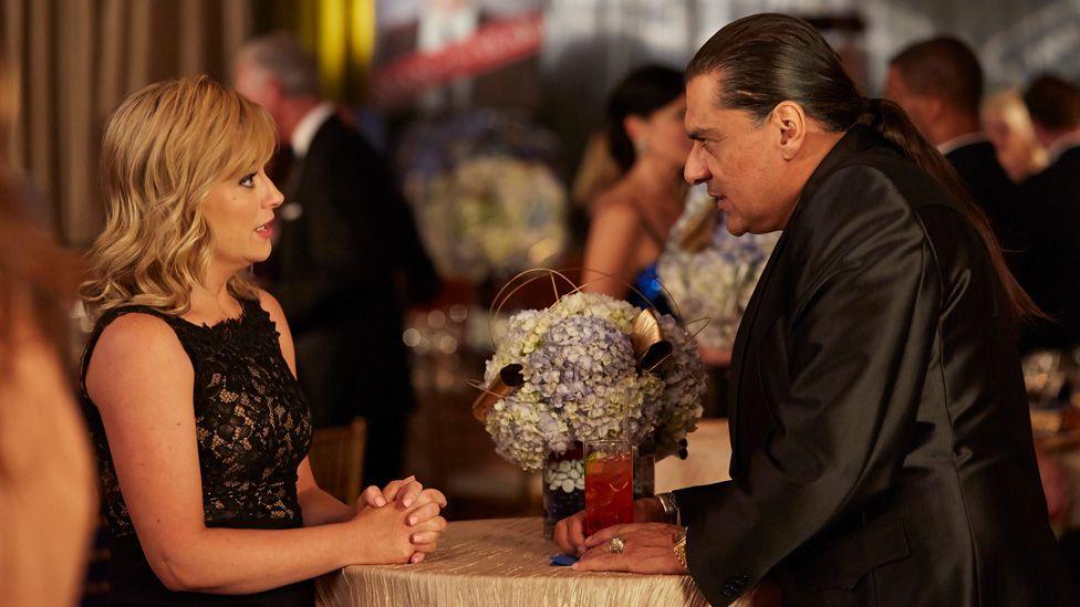 Amy Poehler and Jonathan Joss opposite each other and speaking in character in a scene from a 2017 episode of Parks and Recreation