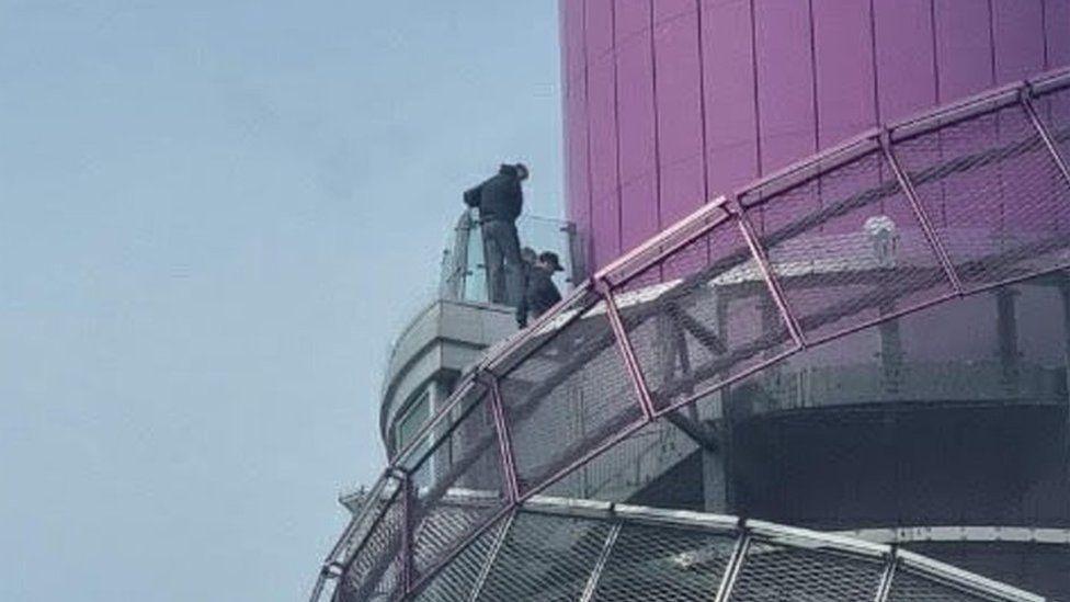 Youths clambering over safety barriers at Redcar Beacon