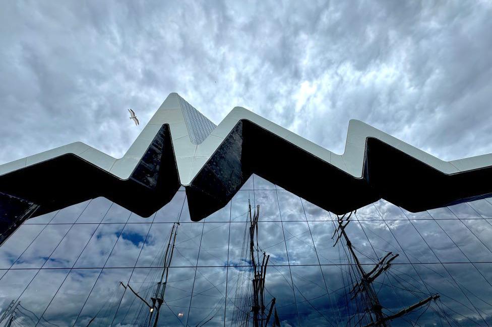 Tall ship reflected in window