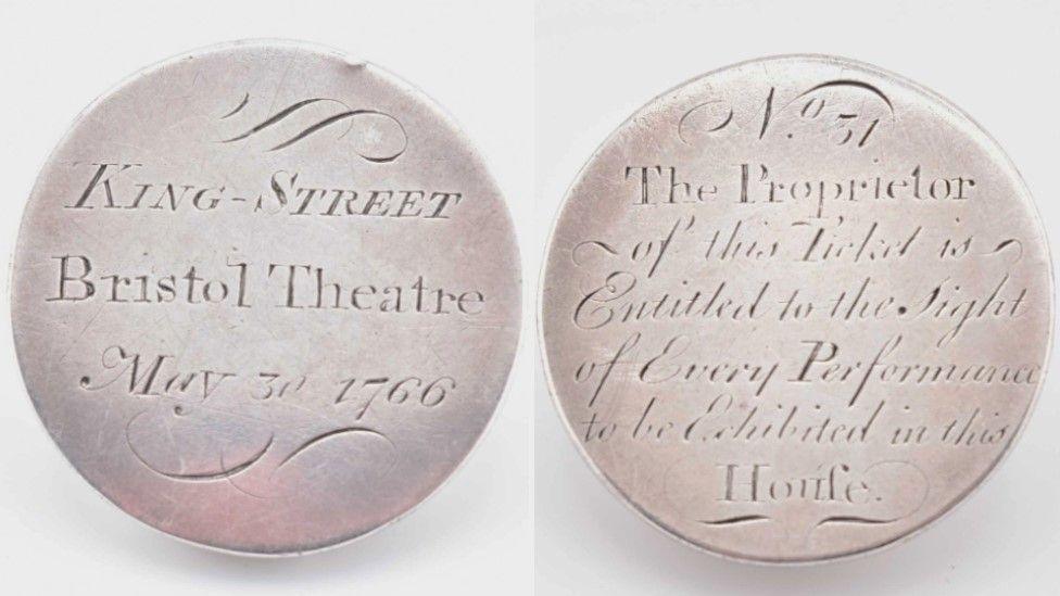 A side by side picture showing the front and back of a rare theatre token. It is a small round silver coin with the words "King Street Bristol Theatre May 30 1766" inscribed onto it. On the side side it says "the proprietor of this ticket is entitled to the sight of every performance to be exhibited in this house".