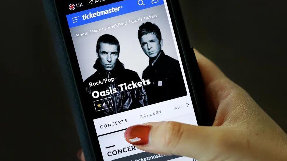 Mobile phone with Oasis tickets on it.