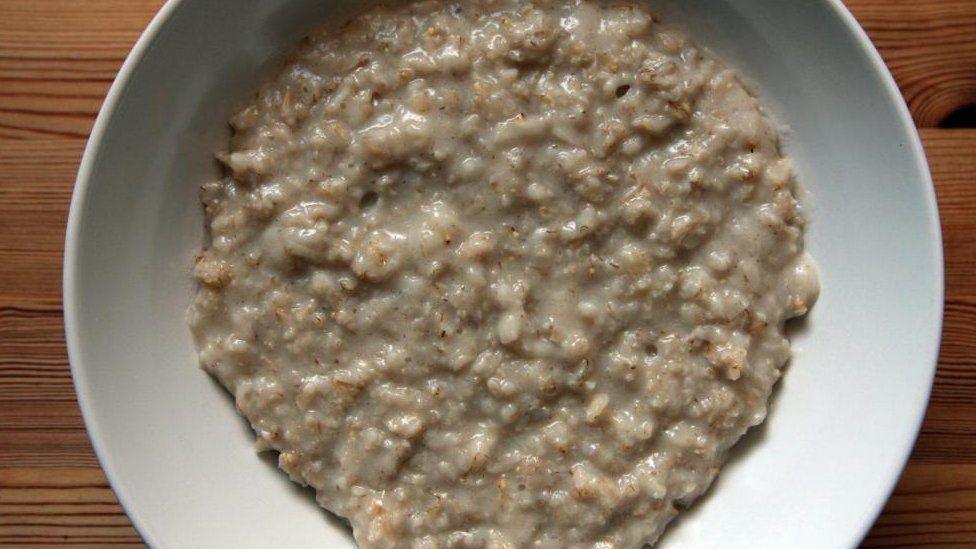 Porridge in a white bowl on a wooden table