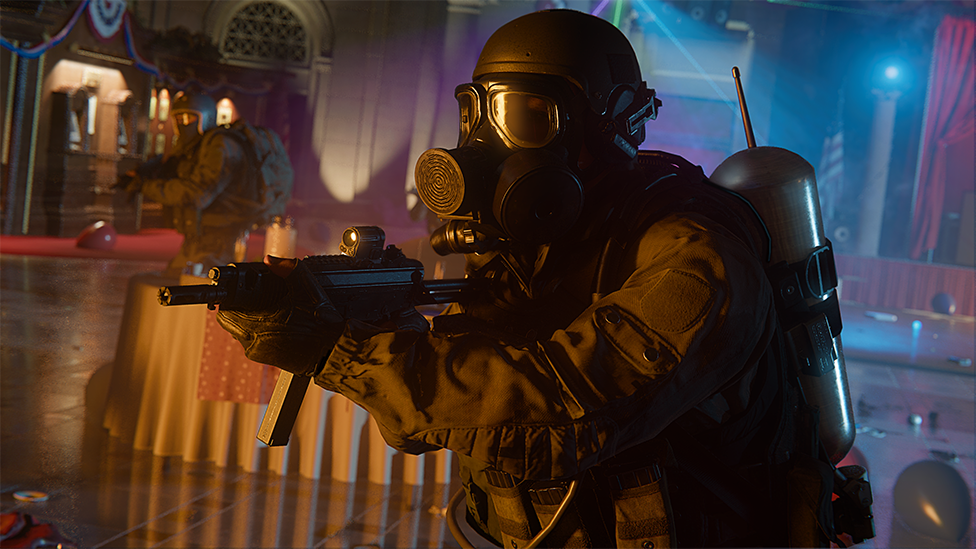 Screenshot from Call of Duty shows a strikingly realistic soldier character wearing protective overalls, a helmet and breathing apparatus as they approach a target. They hold a submachine gun in front of them, ready to fire, and wear an oxygen tank on their back. They are inside a room that has been used for some sort of gathering but shows signs of having been hastily evacuated.