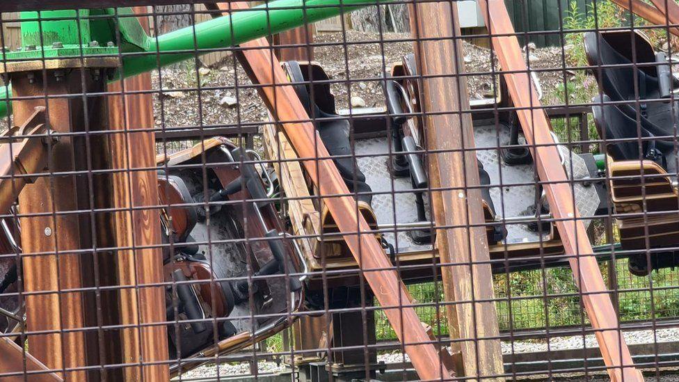 A close up image of the rollercoaster carriages behind a fence