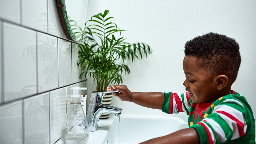 Generic - boy opening tap in bathroom