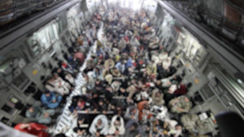 A blurred-out image of people aboard a military plane