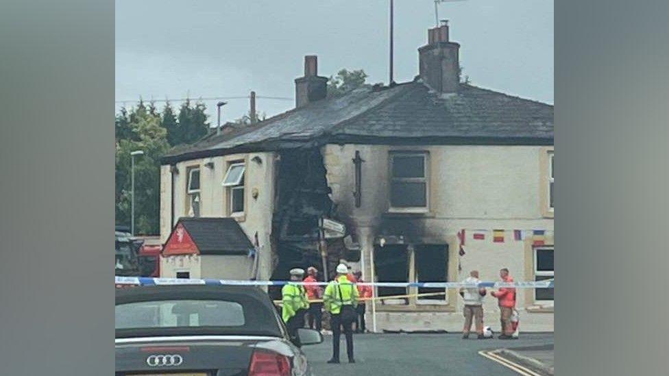 Police and emergency services look on at the damage to the White Lion pub 