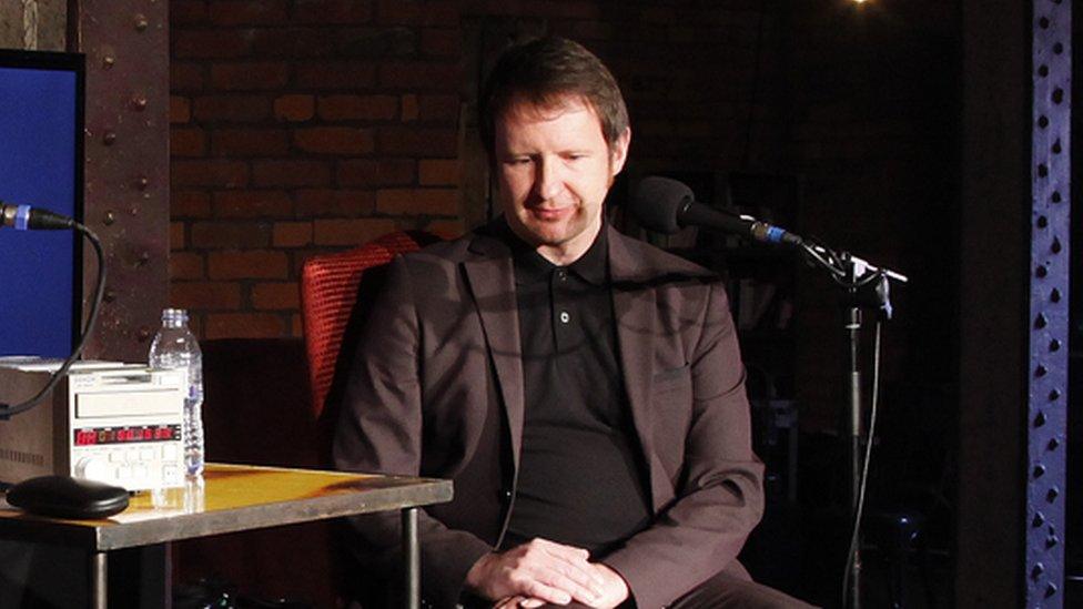 Bob Stanley sitting in a chair in front of a mic