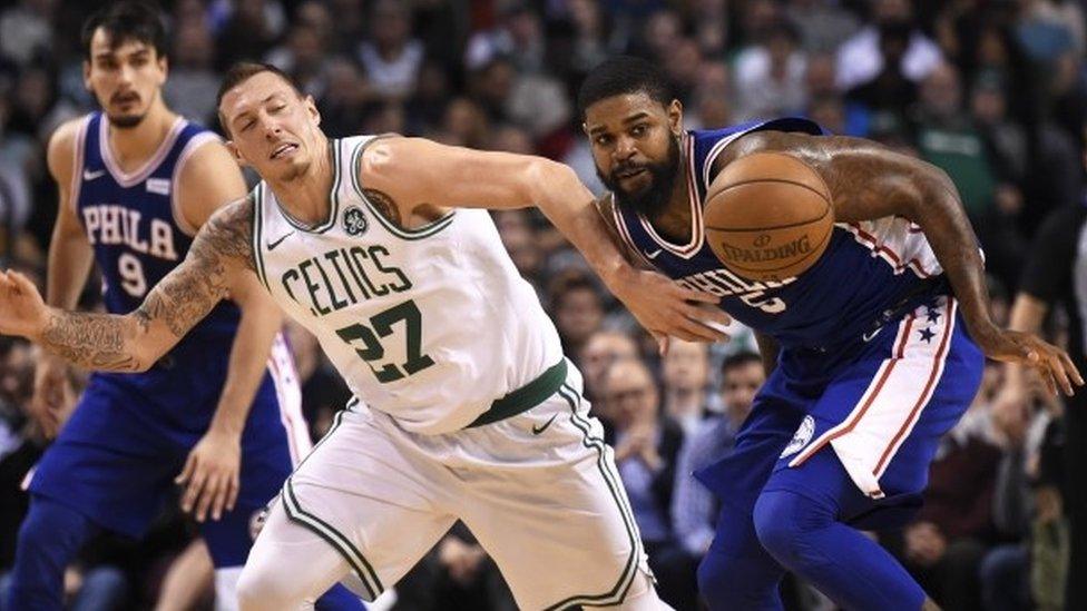 Boston Celtics forward Daniel Theis (27) and Philadelphia 76ers forward Amir Johnson (5) battle for a loose ball