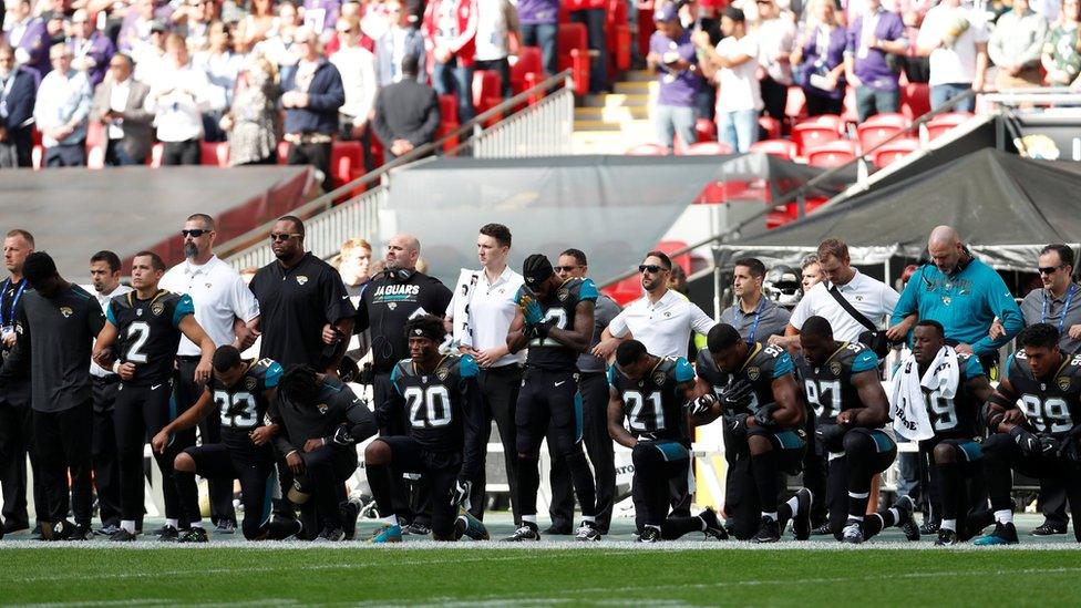 Jacksonville Jaguars players kneel during the U.S. national anthem before the match